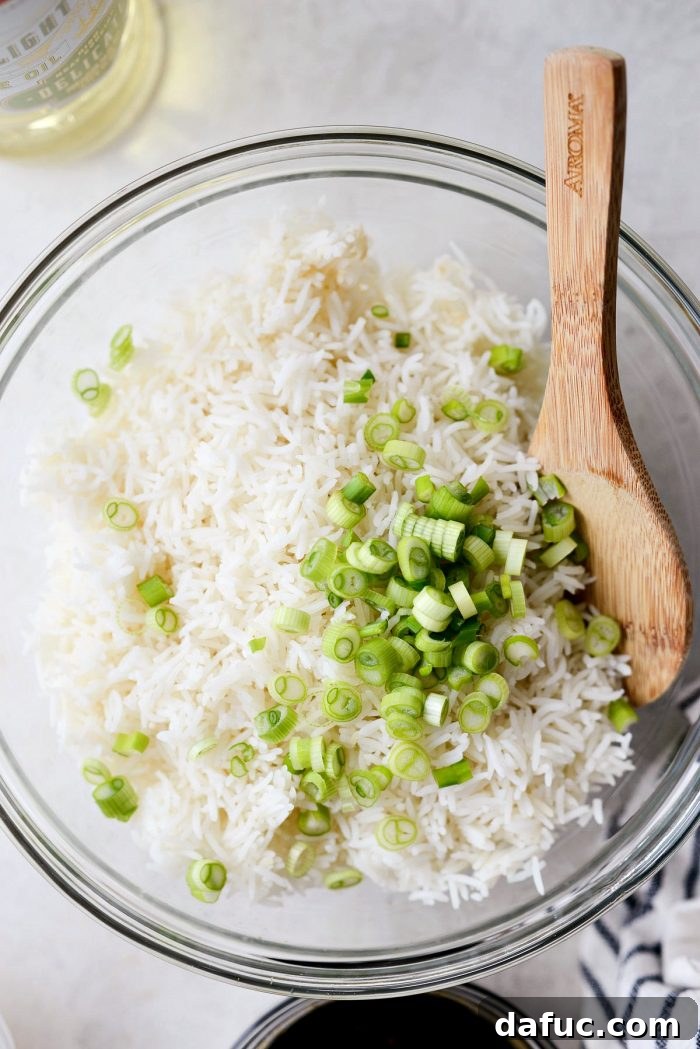Effortless Fried Rice 7 Adding white and light green parts of sliced green onions to day-old cooked rice