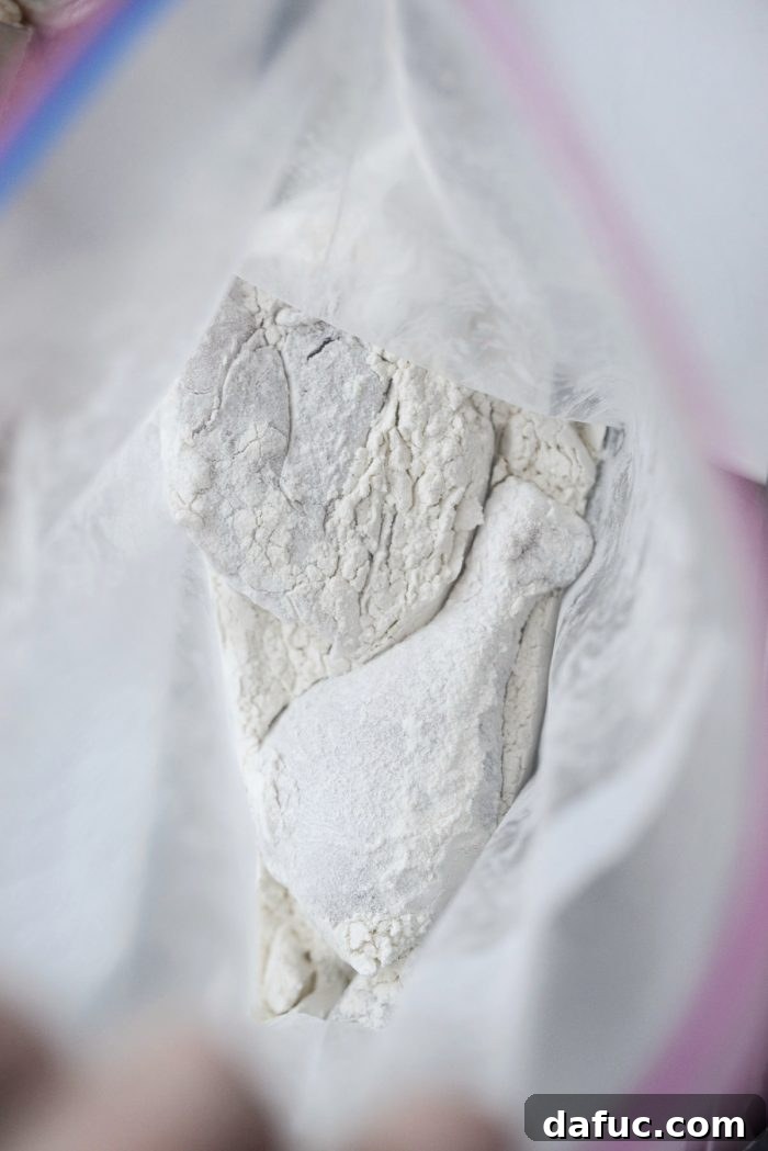 Classic Comfort Baked Chicken 10 Tapping off excess flour from chicken pieces