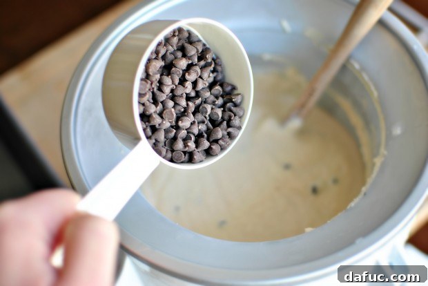 Adding mini chocolate chips to the churning ice cream