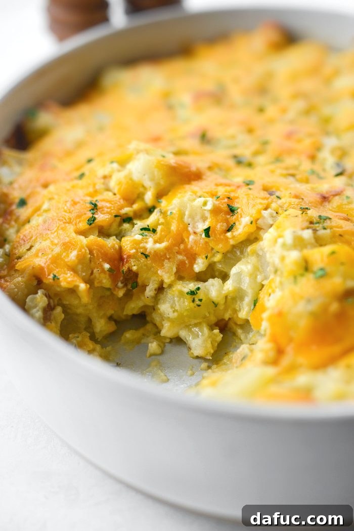 A portion of homemade cheesy potatoes removed from the casserole dish
