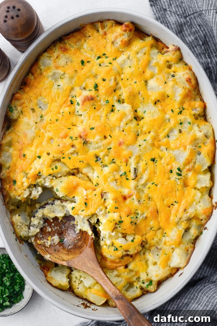 Golden-brown homemade cheesy potatoes with a section scooped out