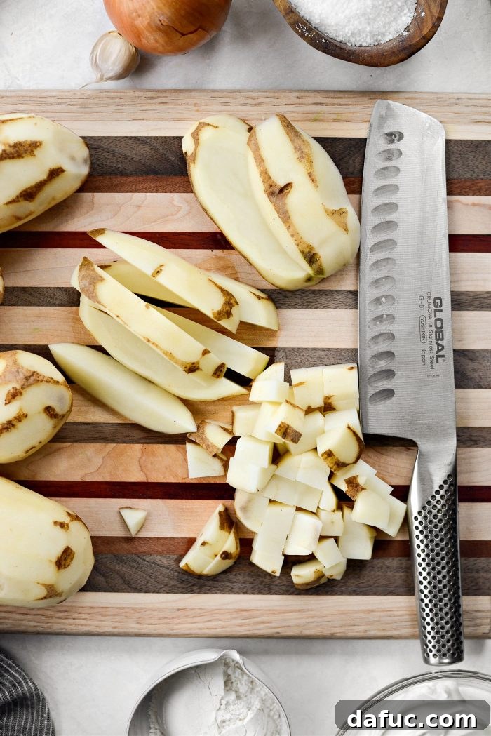 Image showing russet potatoes being scrubbed, peeled, and diced for homemade cheesy potatoes