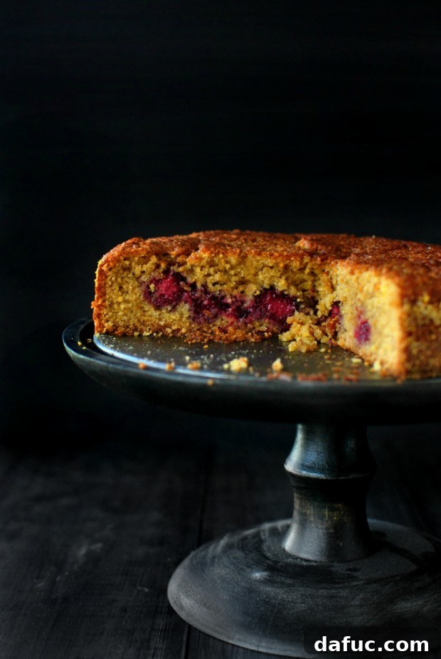 Close-up of a slice of Honey Butter Blackberry Lemon Polenta Cake, revealing the moist interior, polenta texture, and baked blackberries