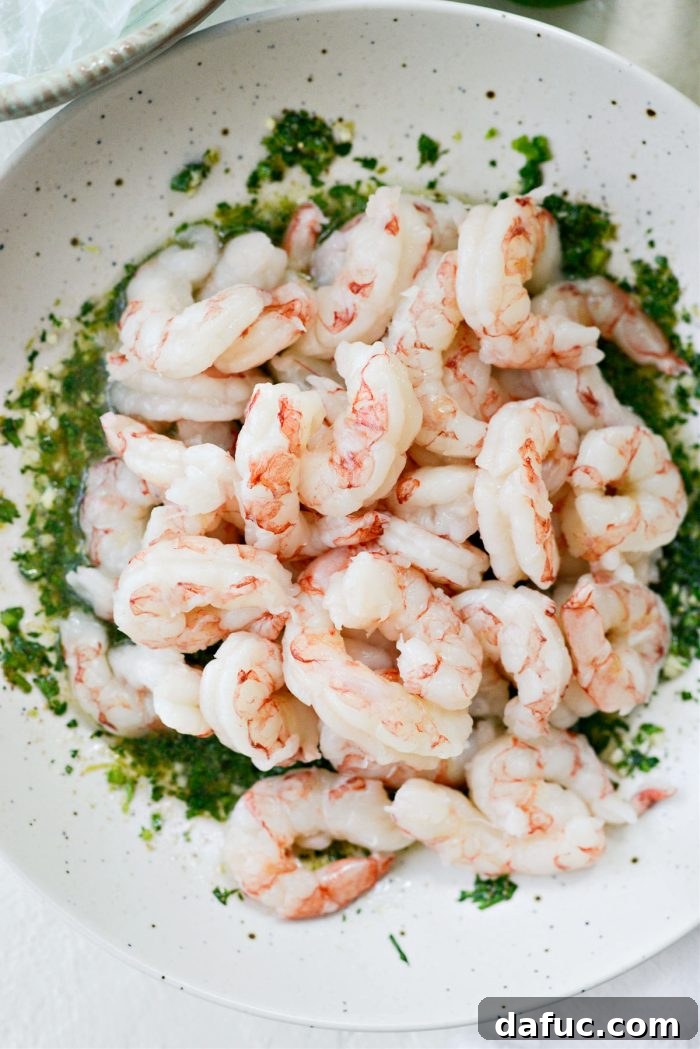 Peeled and deveined shrimp being added to the marinade