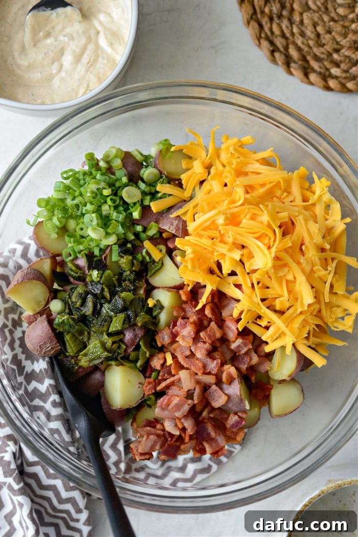 Quartered potatoes, bacon, poblanos, green onion and cheddar in a bowl