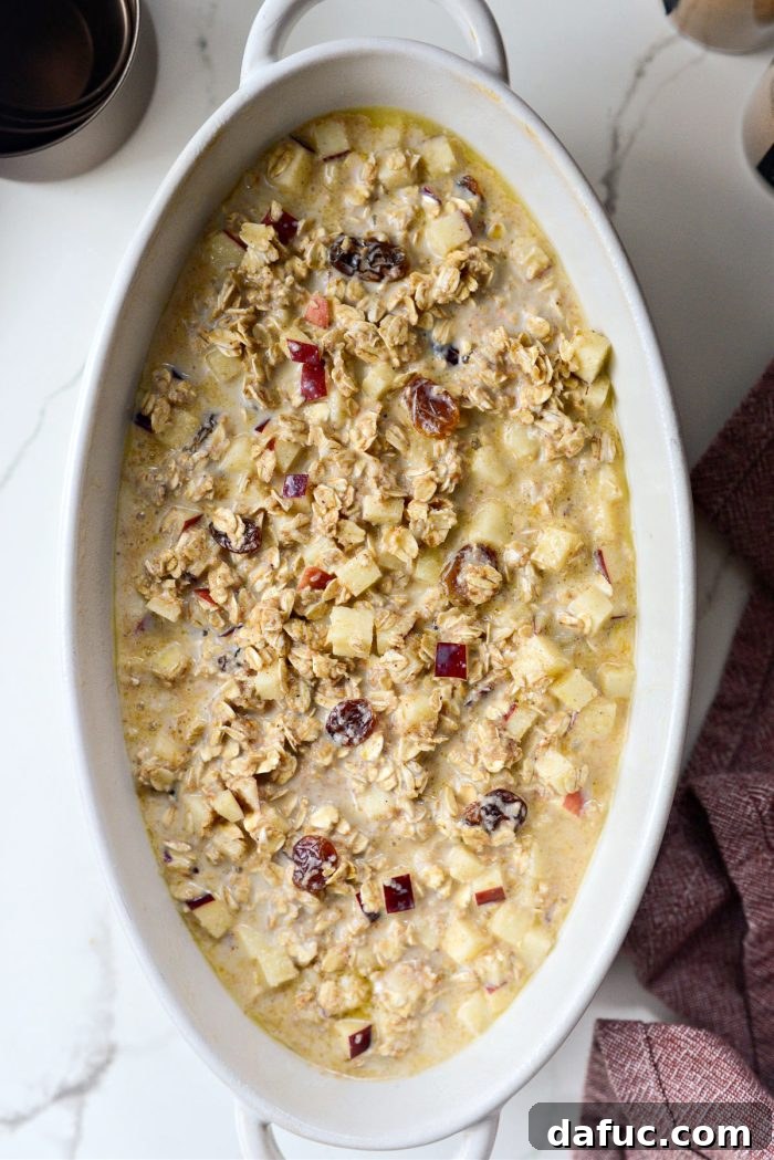 Warm Apple Cinnamon Oat Bake 9 Transferring the mixed Apple Cinnamon Baked Oatmeal mixture into a lightly greased baking dish for baking