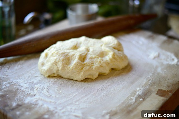 Flatbread dough after being punched down and rolled out, demonstrating its elasticity and readiness for toppings.