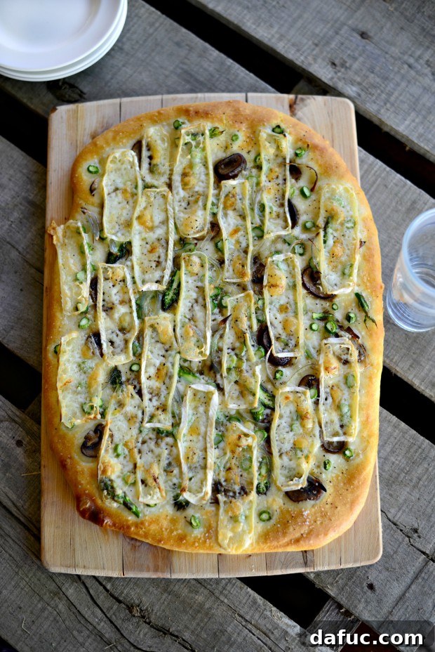 Golden-brown Asparagus, Mushroom, and Brie Flatbread fresh out of the oven, with bubbly melted cheese and crispy crust.