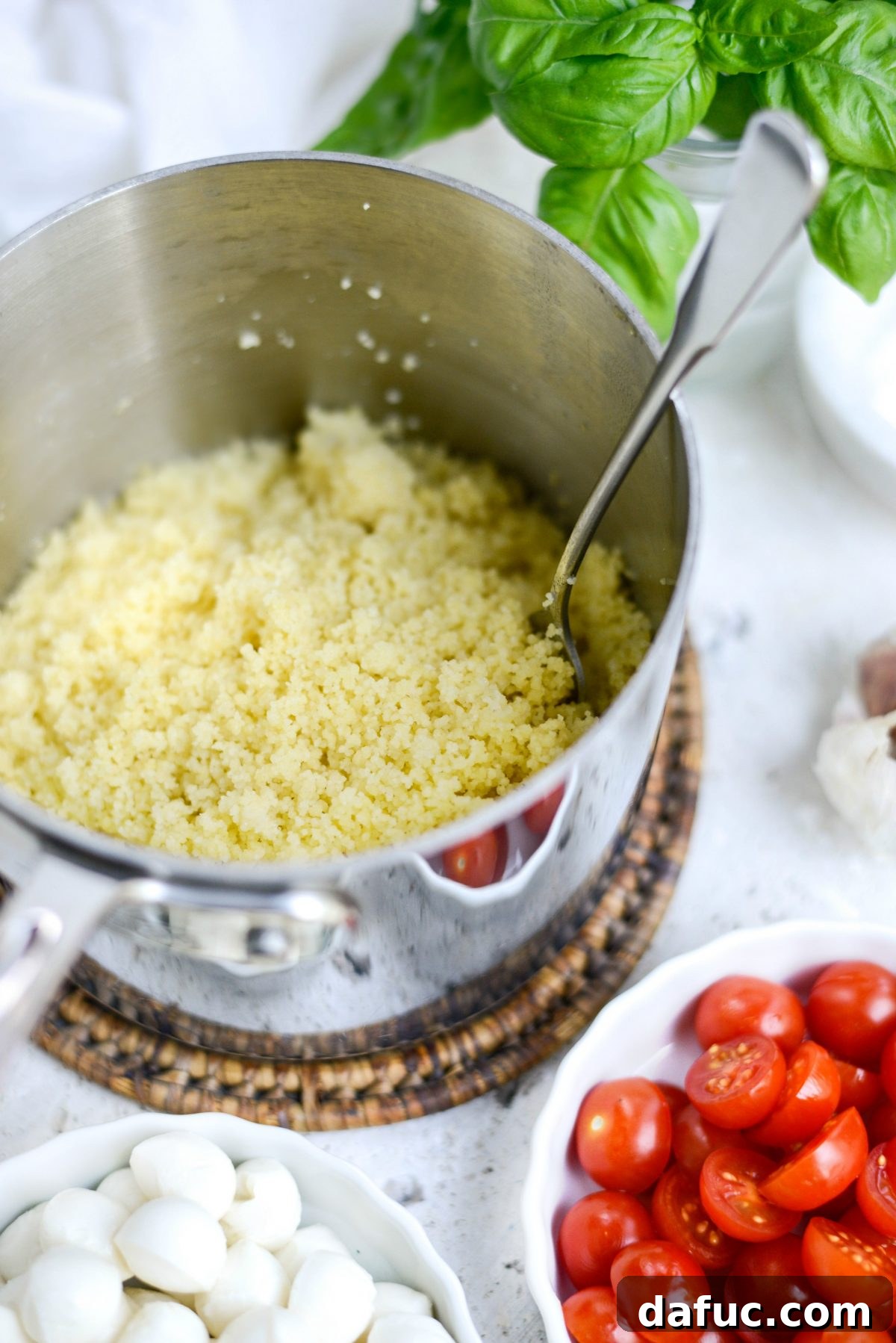 Vibrant Caprese Couscous 6 Fluffing couscous with a fork