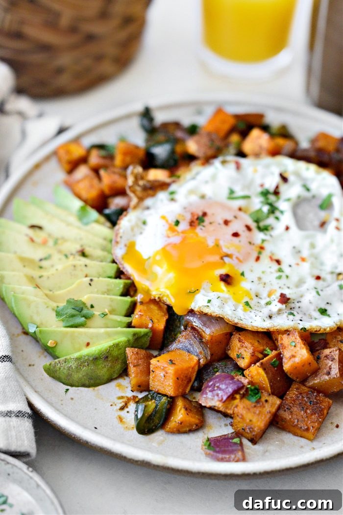 Sweet Potato Home Fries served with avocado and a fried egg on a plate.