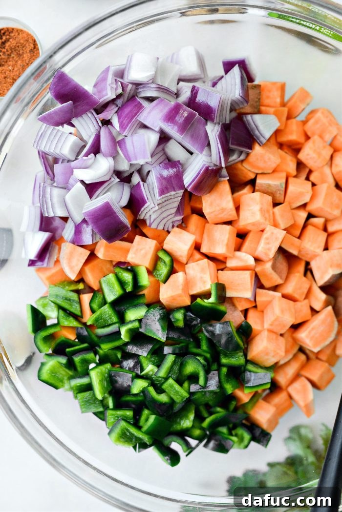 Diced sweet potatoes, poblano pepper, and red onion in a mixing bowl.