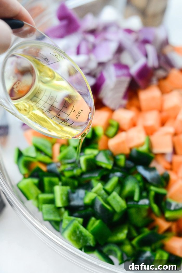Drizzle avocado oil over diced sweet potatoes, onion, and poblano.