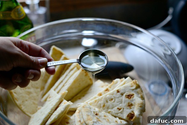 Everything Seasoned Pita Crisps 9 Pita bread being cut into eight triangular wedges