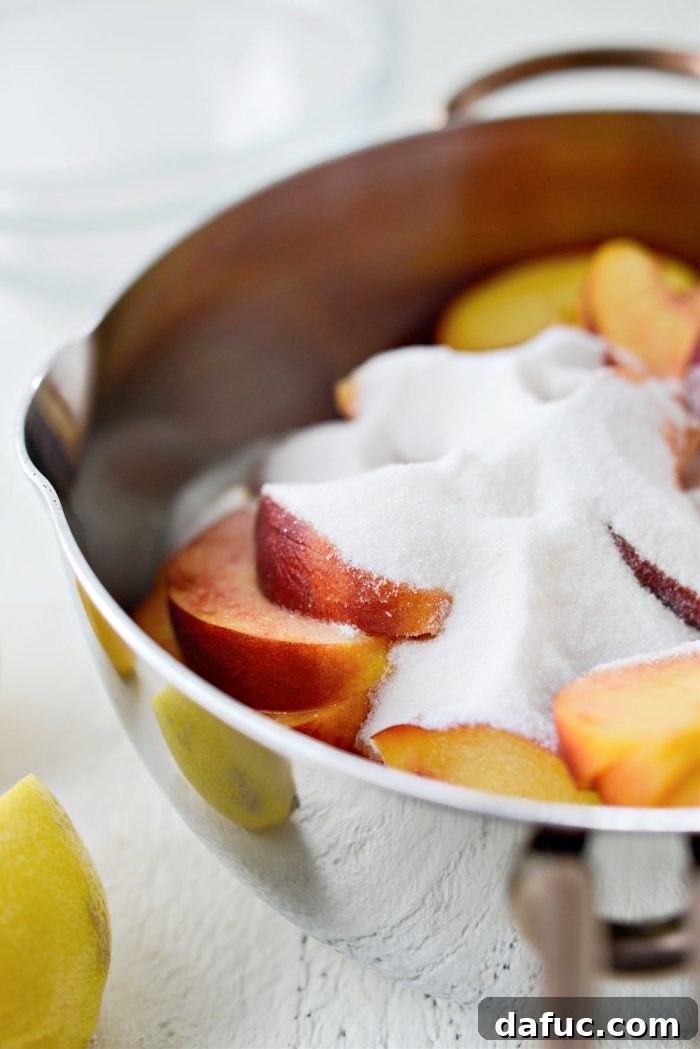 Adding granulated sugar to the sliced peaches in a saucepan