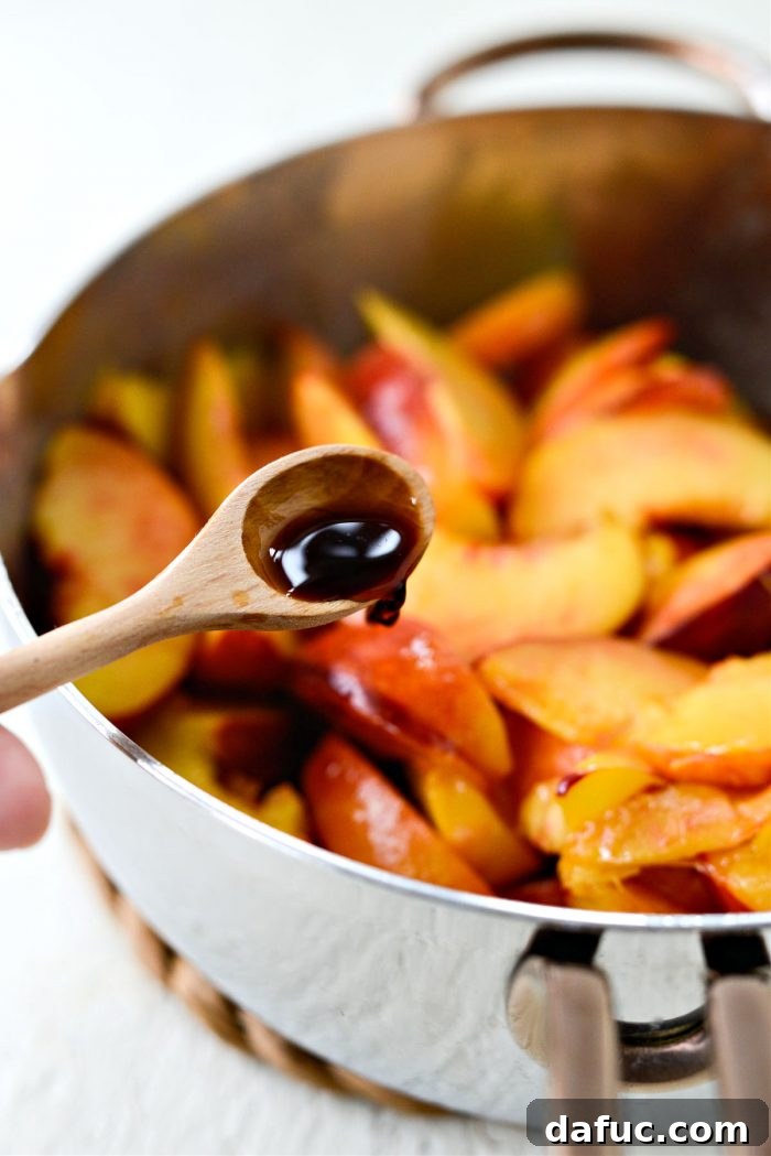 Removing the peach mixture from heat and adding vanilla extract