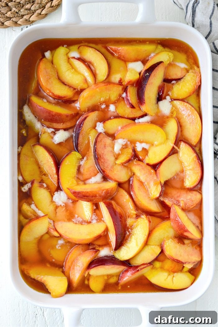 The assembled Brown Butter Peach Cobbler in the baking dish, ready to go into the oven