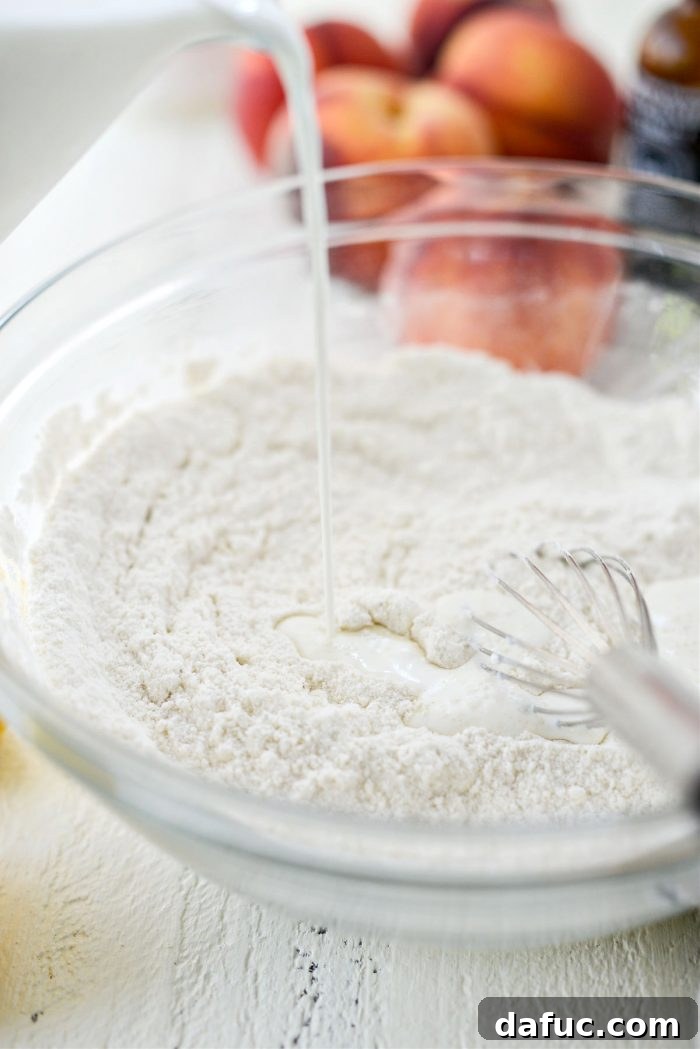 Adding half & half to the dry ingredients in a mixing bowl for the cobbler batter