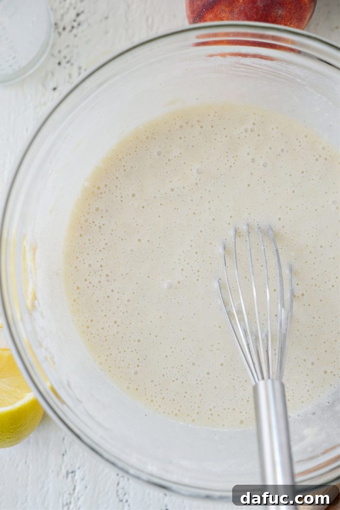 The mixed cobbler batter, a smooth white mixture, in a bowl
