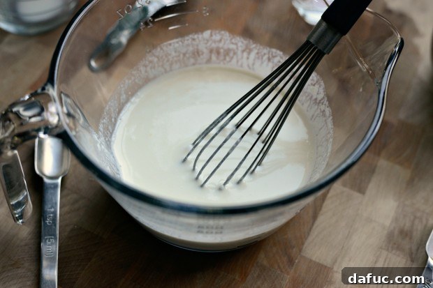 Pillowy Naan Perfection at Home 11 The yeast and yogurt mixture being whisked together until smooth and fully combined.