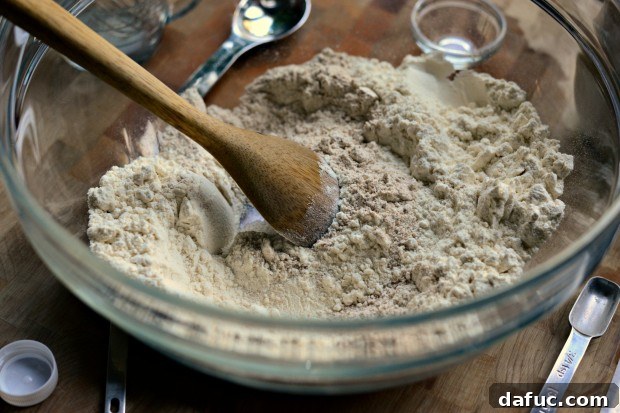 Pillowy Naan Perfection at Home 13 Dry ingredients for naan being stirred with a spoon to ensure even distribution.