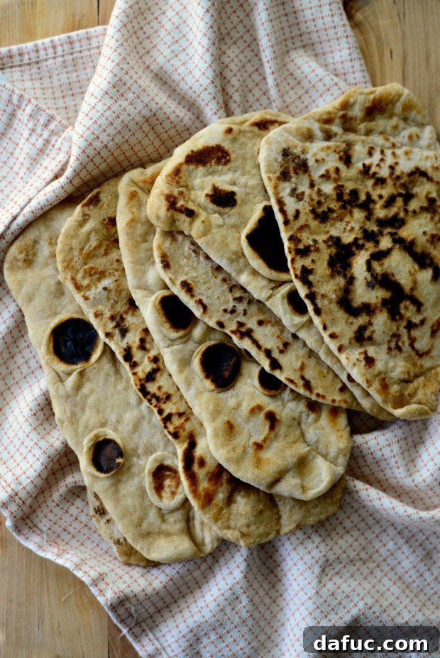 Pillowy Naan Perfection at Home 33 A stack of freshly made homemade naan bread, ready to be enjoyed.