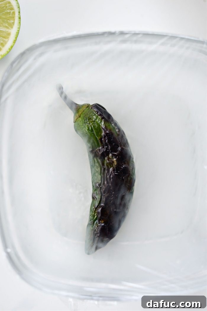 Zesty Tomatillo Avocado Salsa 8 Adding broiled jalapeño to a bowl and covering it with plastic wrap to steam.