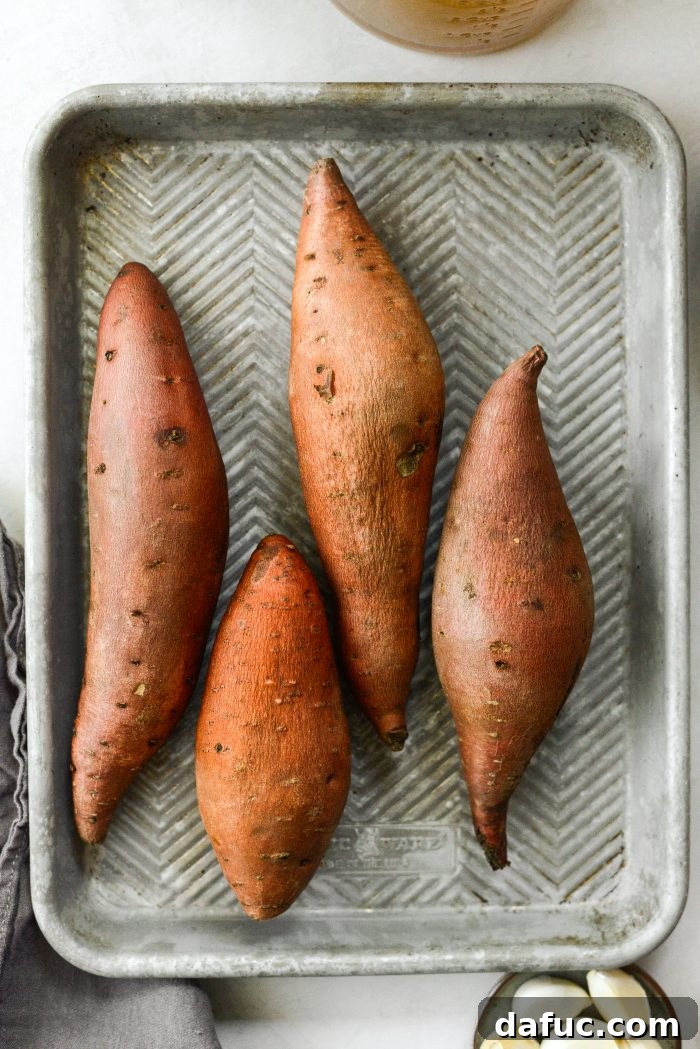 Vibrant Sweet Potato Tomatillo Bisque 5 Sweet potatoes ready for roasting on a baking sheet