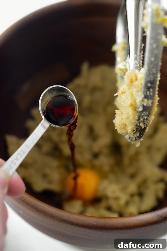 Decadent Merlot-Infused Dark Chocolate Cookies 10 Pure vanilla extract being poured into the mixer with the other wet ingredients.