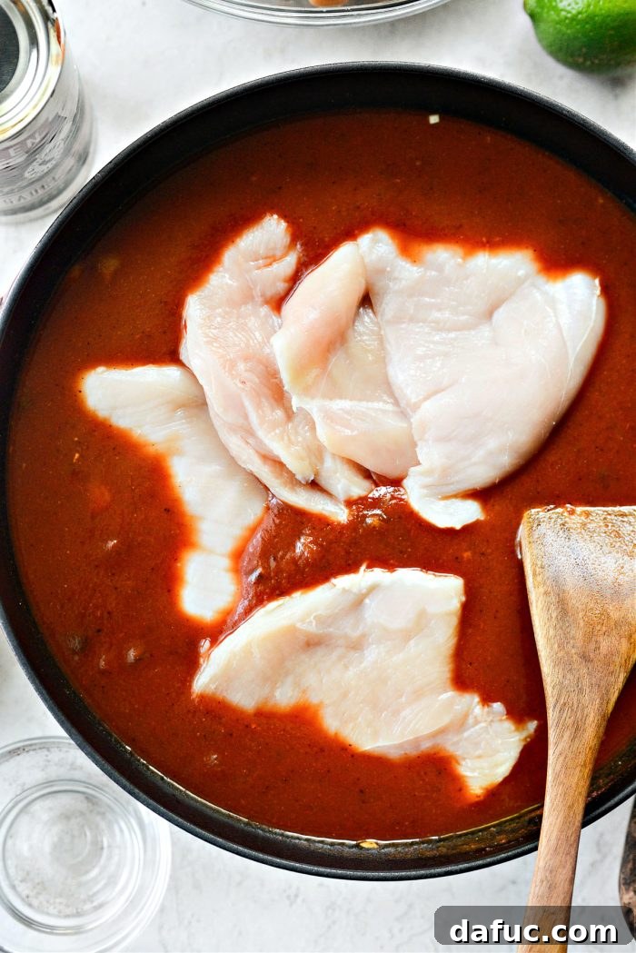 Smoky Southwest Chicken Chili 9 Raw chicken breasts submerged in chili sauce in a pot