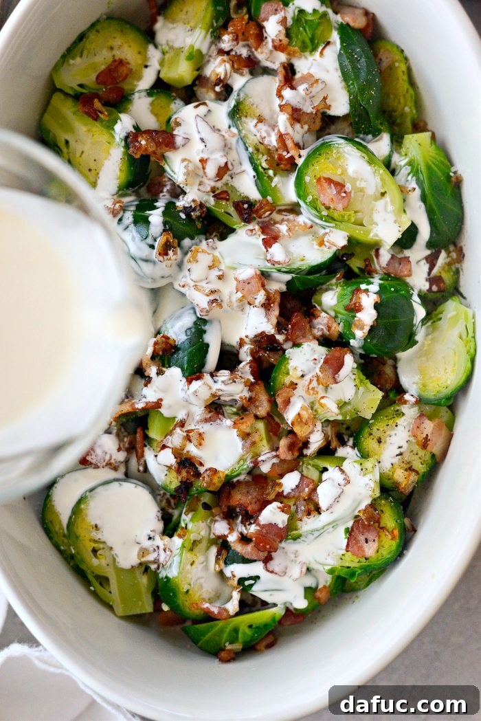 Creamy Cheesy Brussels Sprout Bake 5 Pouring heavy cream over the Brussels sprouts and bacon in the baking dish.