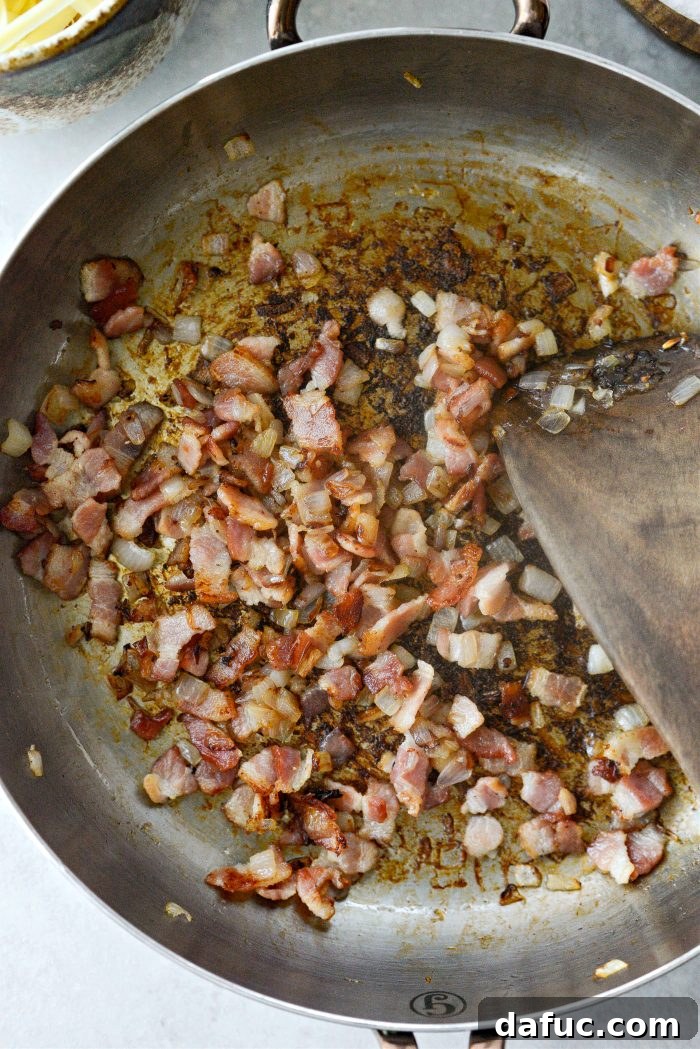 Creamy Cheesy Brussels Bake 8 Crispy bacon and tender shallots in a skillet, ready for the gratin