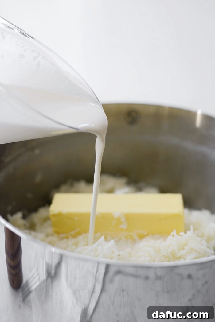 Heirloom Mashed Potatoes 16 pouring in half and half - half and half being poured into mashed potatoes