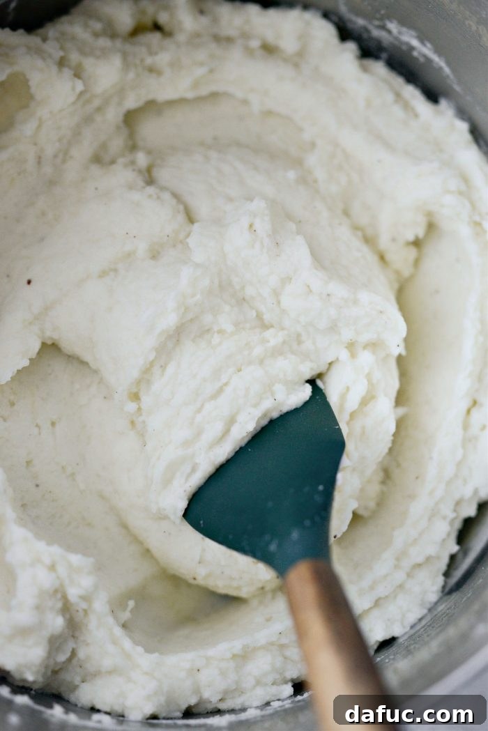 Heirloom Mashed Potatoes 19 stir and adjust seasoning and cream - stirring finished mashed potatoes in a pot