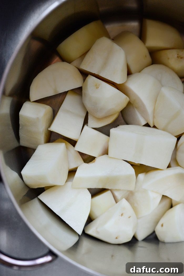 Heirloom Mashed Potatoes 7 add potatoes to pot - cut potatoes being added to a large stockpot