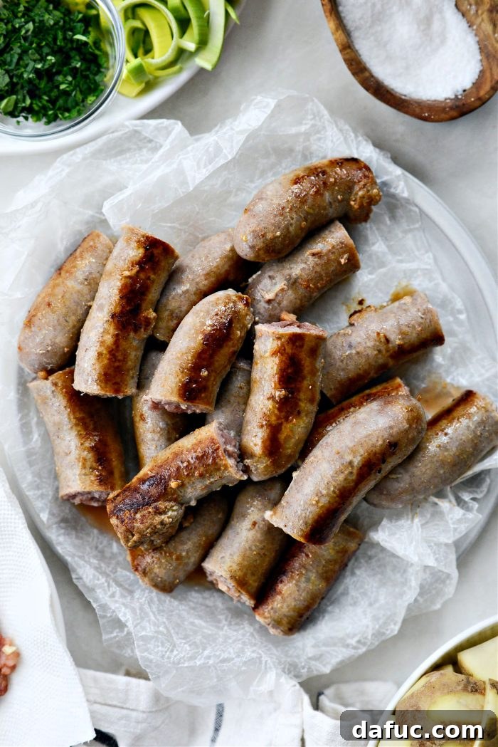 Dublin's Hearty Comfort Coddle 13 Slightly cooled pork sausages being cut into halves or thirds on a cutting board.