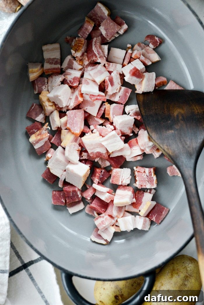 Dublin's Hearty Comfort Coddle 5 Diced applewood smoked bacon being added to a Dutch oven to render fat.