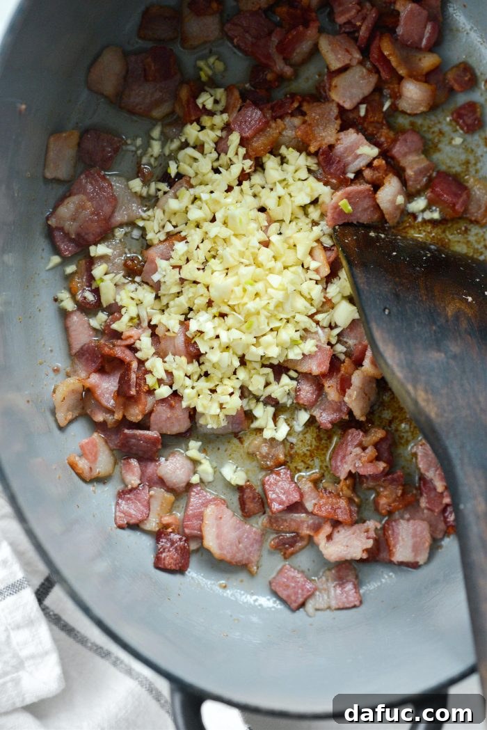 Dublin's Hearty Comfort Coddle 9 Crispy bacon and minced garlic cooking together in a Dutch oven.