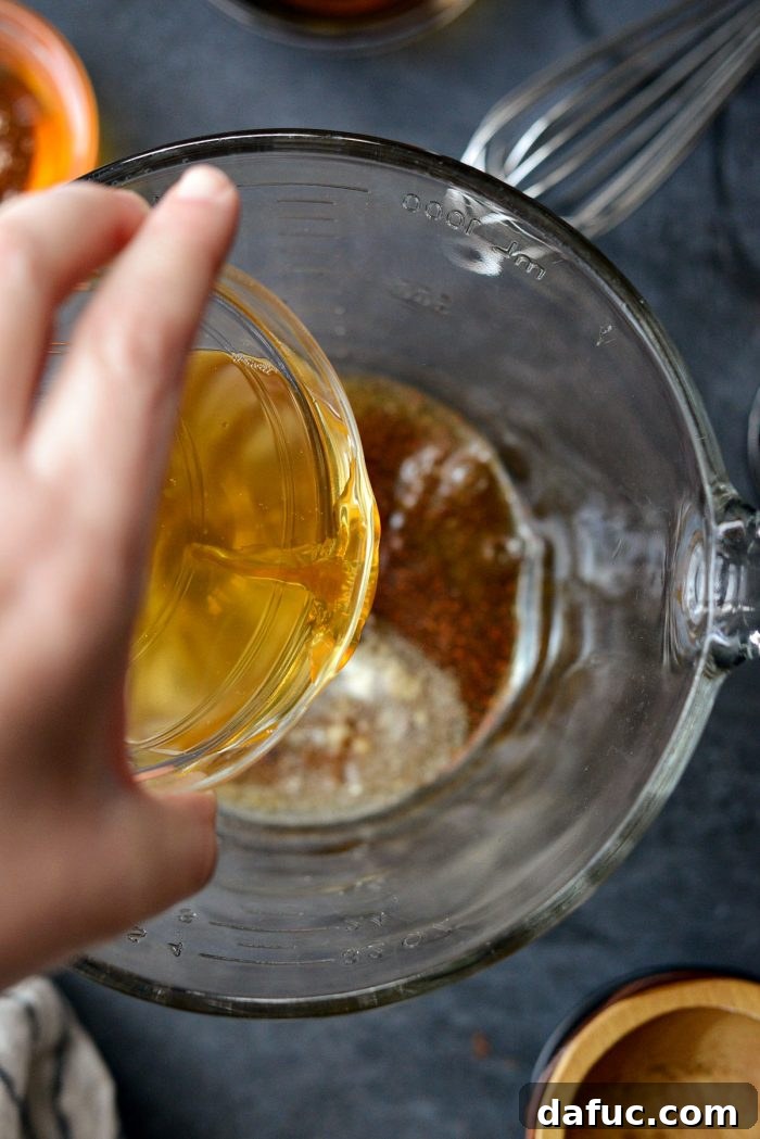Adding apple cider vinegar to the mixing bowl.