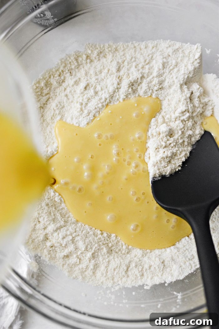 Pouring wet muffin mixture into dry ingredients