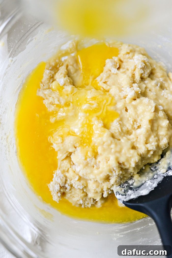Pouring melted butter into muffin batter