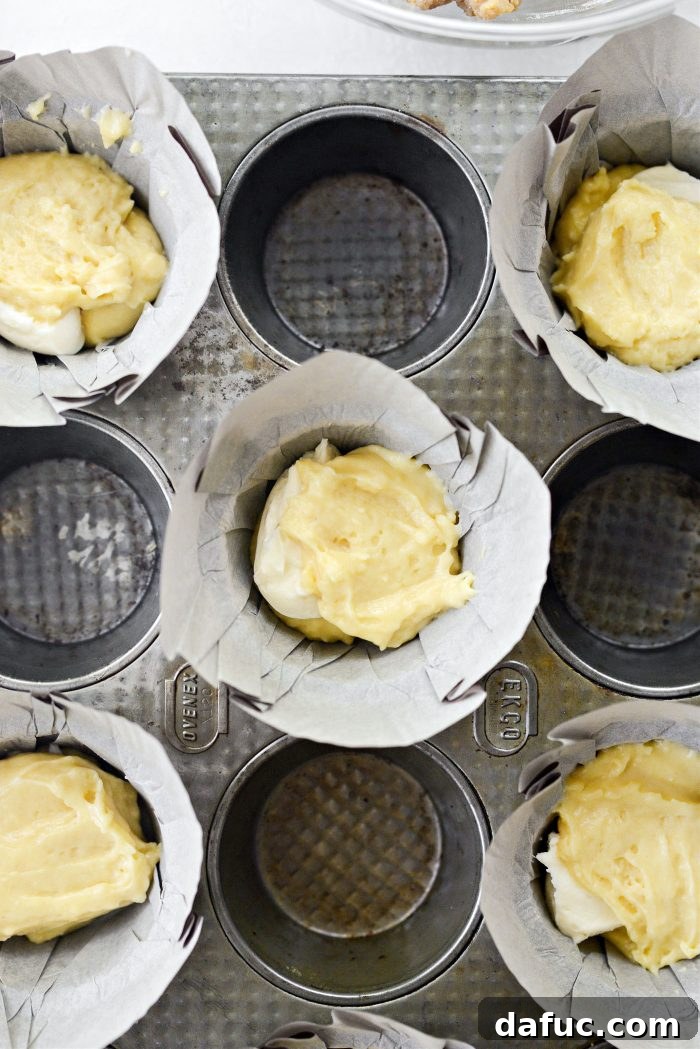 Dividing remaining muffin batter among filled liners