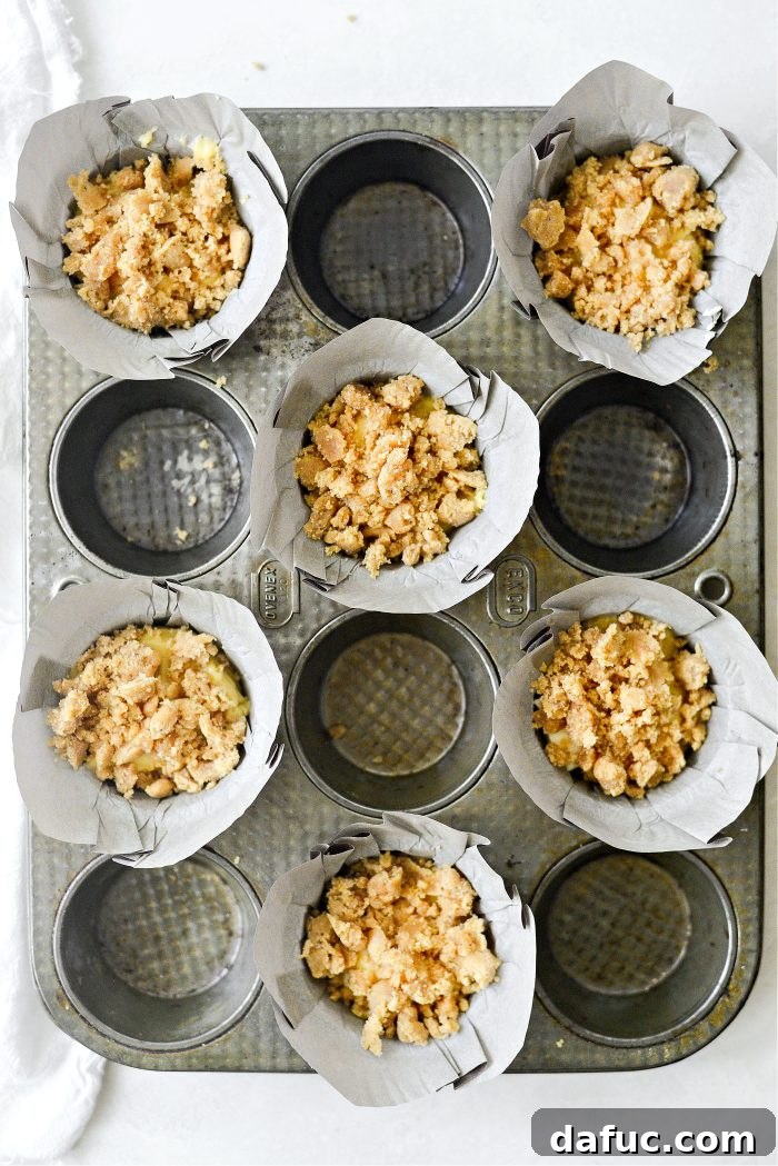 Sprinkling streusel topping over muffins
