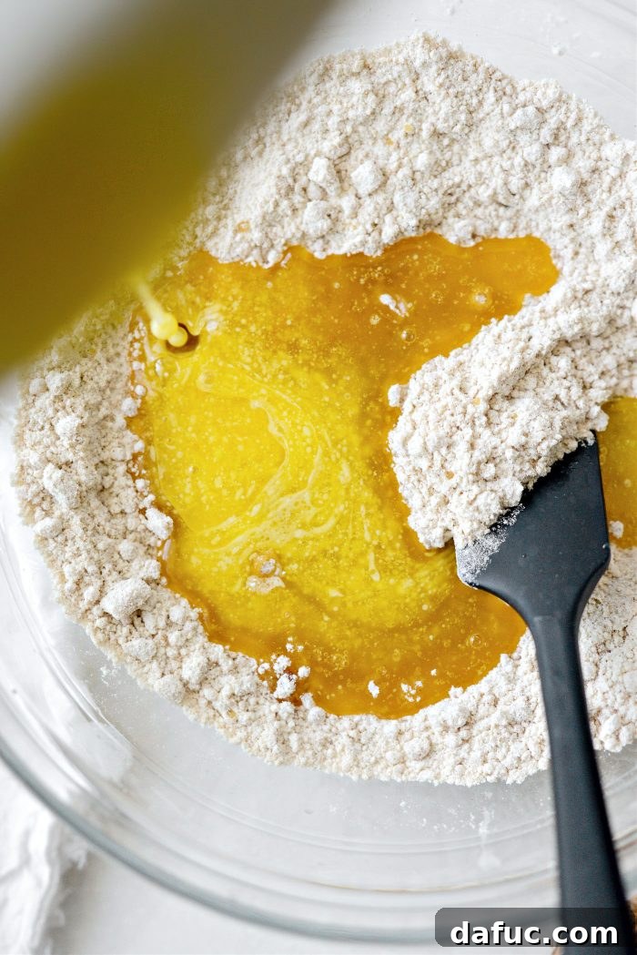 Pouring melted unsalted butter into streusel mix
