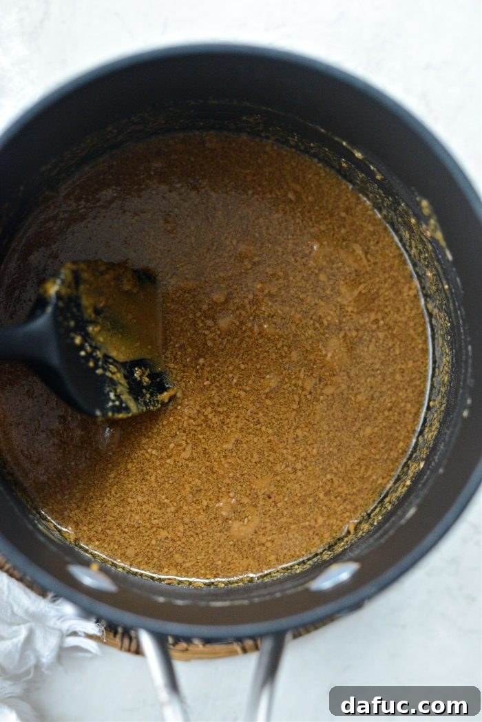 Stirring peanut butter and maple syrup over low heat