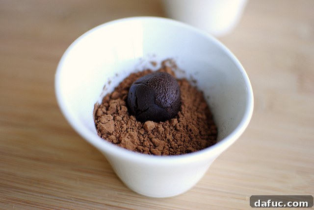 Mystic Mayan Truffles 15 Rolling finished truffles in a bowl of cocoa powder