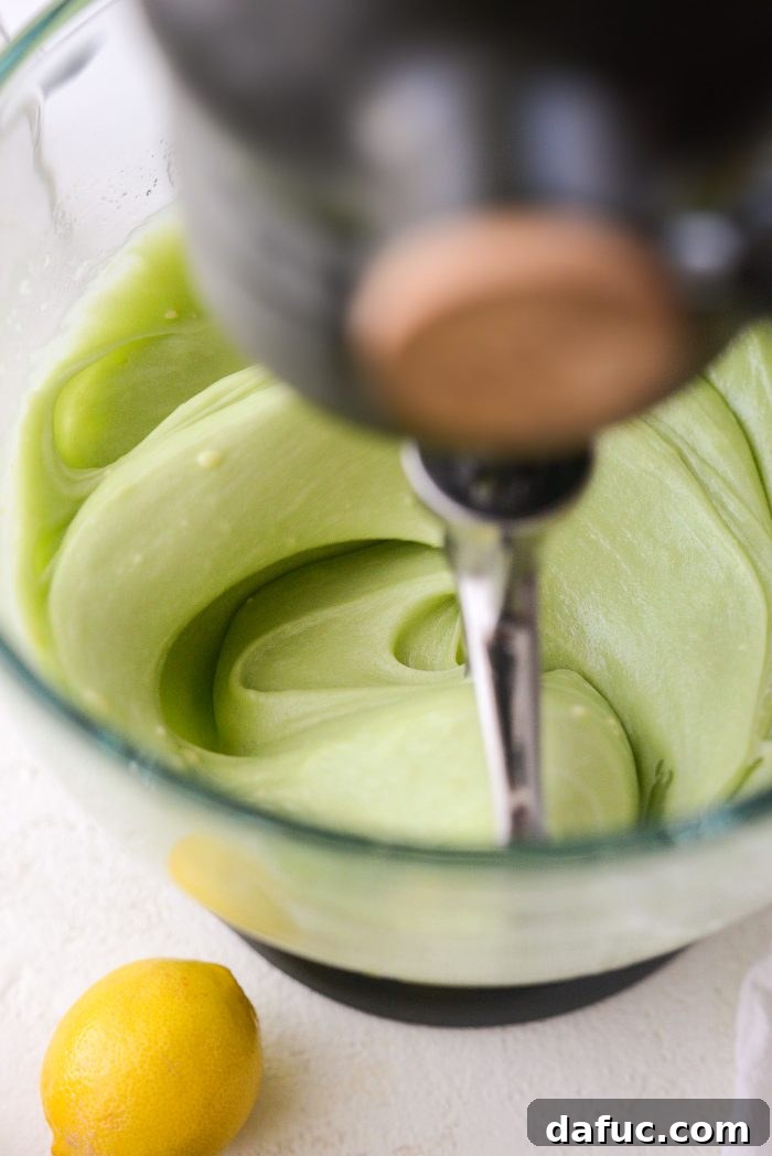 Mixing the cake batter on medium-high speed for one minute to achieve a light and airy texture.