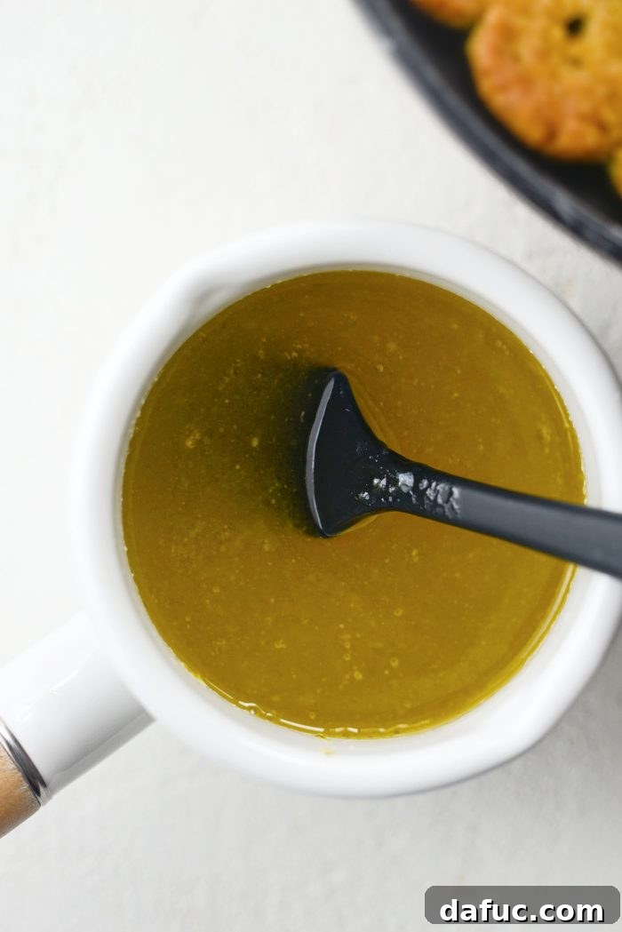 The citrus glaze simmering gently in a saucepan, with butter and sugar melted into the lemon and lime juice.
