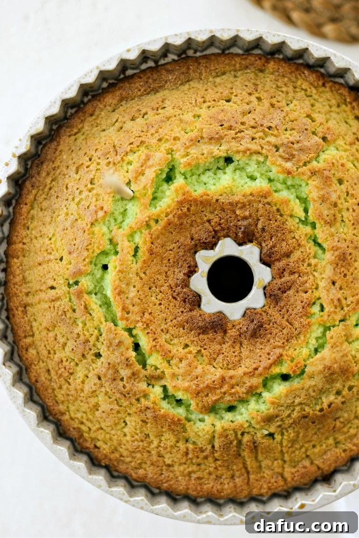 Freshly baked bundt cake with holes poked into its surface, ready to absorb the citrus glaze.