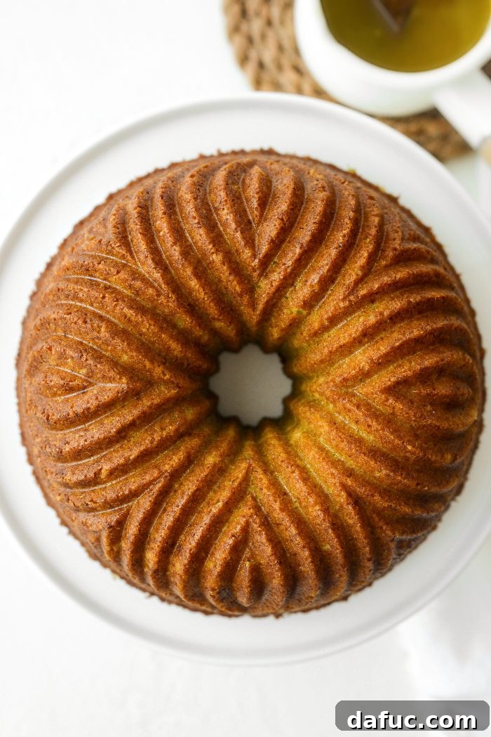 Carefully inverting the Lemon Lime Bundt Cake onto a serving plate or stand after it has cooled slightly in the pan.