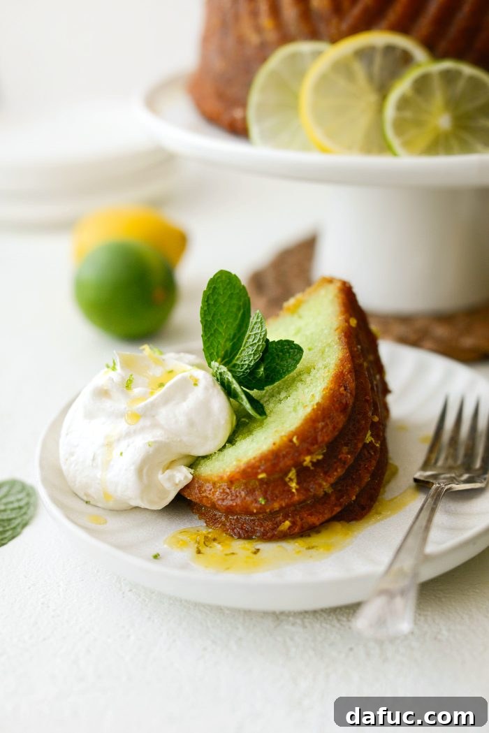 A close-up of a beautifully sliced Lemon Lime Bundt Cake on a white plate, revealing its moist interior.